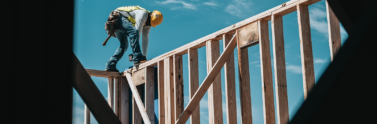 construction person working on wooden house frame