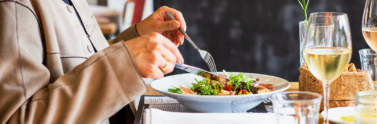 Person sitting at a restaurant table eating