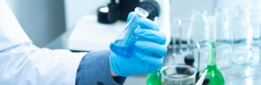 Person holding laboratory flask