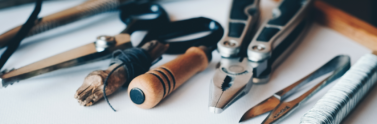 Several handheld tools lined up on white paper
