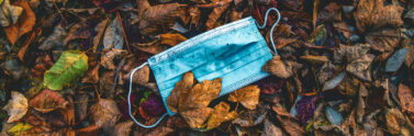 photo of medical mask on a pile of dried leaves